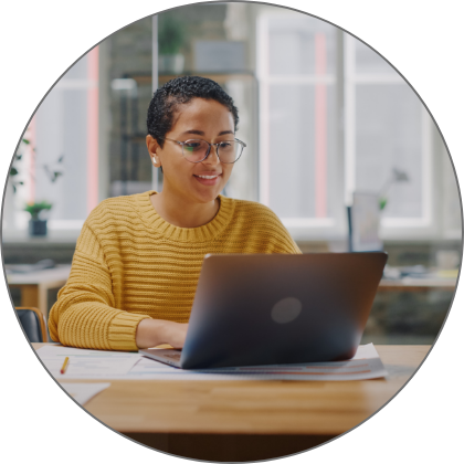 A woman sitting at a desk in front of a laptop